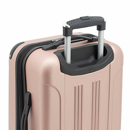 Close-up of a rose gold hardshell suitcase with a telescopic handle.